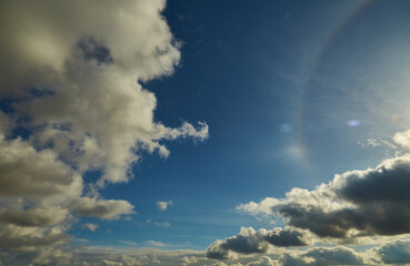 A mysterious halo in the blue sky. A glowing ring around the sun breaks through thin clouds,...