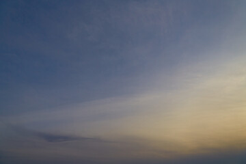 Magical atmosphere of a sunset with a misty sky and cirrus clouds, sunset reflections in the sky, hazy sky with clouds at sunset, sky in pastel shades with sunlight and clouds.