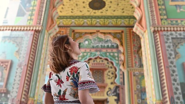 An Asian woman photographing while traveling through the artistic Patrika Gate, the ninth gate of Jaipur, Rajasthan, India