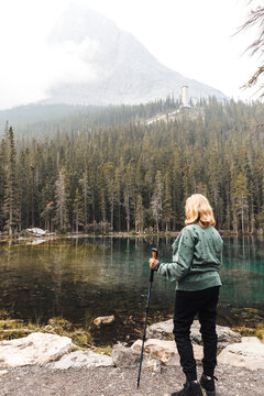 Mature woman standing by a lake in the mountains on a hazy day