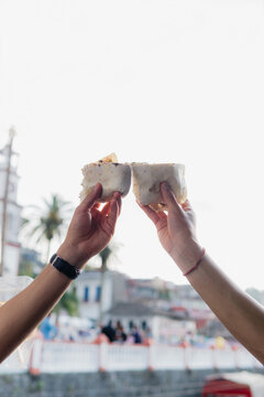 A pair of friends sharing a burrito.