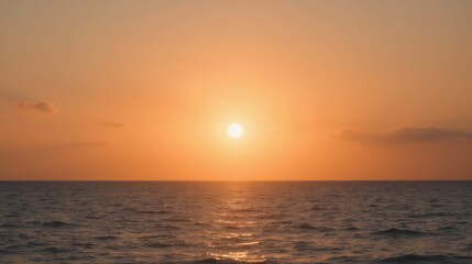 Serene Sunset Over Calm Ocean Waves with Warm Orange Sky