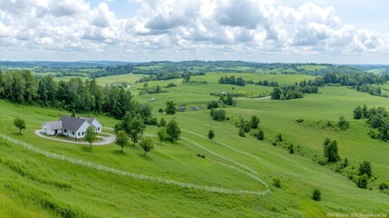 Obraz premium Hilltop house overlooking rolling green fields, sunny day