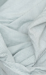Soft striped fabric in light gray tones with a close-up view of the natural folds.