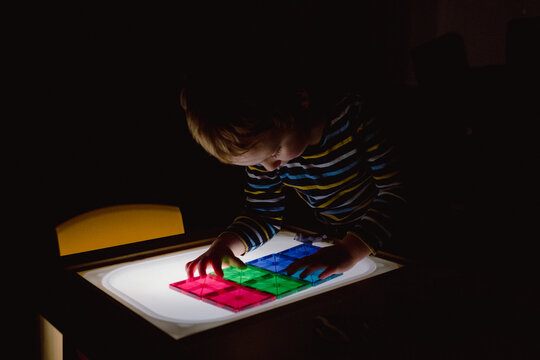 Child Fully Immersed in Light Panel Play