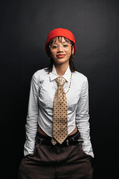 Stylish woman wearing red beret, white shirt and tie posing