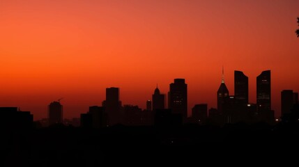 Naklejka premium Vibrant Urban Sunset Over City Skyline with Silhouetted Buildings