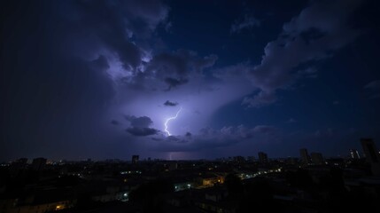 Fototapeta premium Dramatic Lightning Strike Illuminates Dark City Skyline at Night