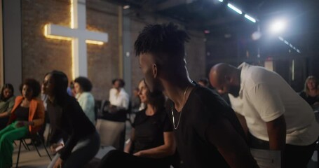 Congregation sitting during church service, listening attentively with illuminated cross in background, diverse community gathering for faith and spiritual connection