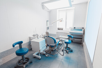 Modern Dental Clinic with Blue Stomatology Chair and Equipment. Professional Dentist Office, Sterile Medical Interior for Oral Care and Treatment. Interior of new modern dental office