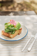 Sandwich with avocado and salmon on a brioche bun