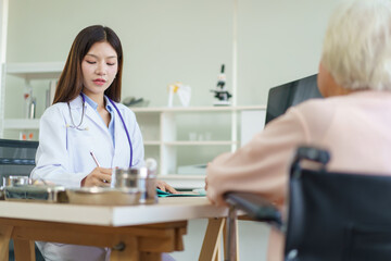 Fototapeta premium Asian elderly woman see have an annual health check and taking with doctor.