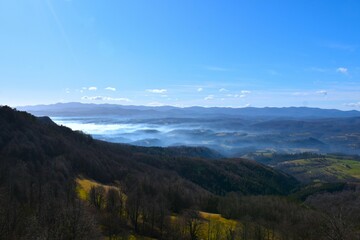 Misty landscape with forest covered hills in Notranjska, Slovenia