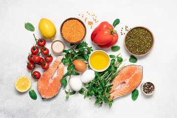 Cooking or buying healthy food background. Assortment of fresh fish with aromatic herbs, spices, vegetables and beans