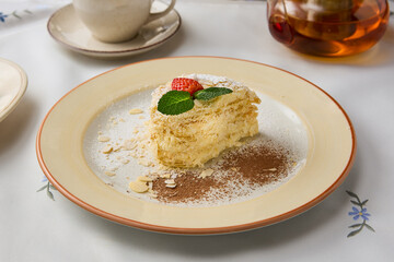 Elegant Presentation of Napoleon Pastry with Tea, Highlighting Minimalist Artistic Techniques