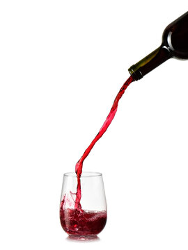 Red wine high pouring in a stemless glass on white background, studio shot