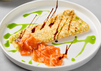 Gourmet Salmon Omelette with Artistic Sauce Drizzles on Elegant White Plate