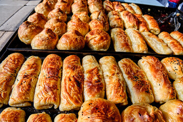 Samsa made from puff pastry on a baking sheet, freshly baked, golden brown, appetizing. Central Asian cuisine