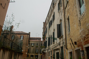 Old ancient residential house stone building with windows with shutters of Venetian narrow streets, Venice, Italy