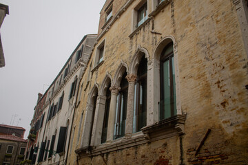 Carved Gothic windows on ancient residential house stone building of Venetian streets, Venice, Italy