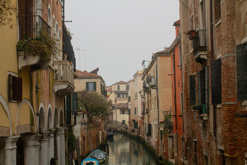  Small сanal in Venice and a street with facades of old yellow and brown residential houses, Italy, Veneto region