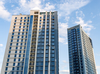 Fototapeta premium Modern high-rise residential and commercial building with sleek facades and large windows, contemporary urban architecture in a growing city district.