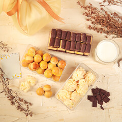Indonesian Lebaran snack, nastar, and chocolate cookies. A delightful spread of baked treats including pastries, chocolates, and a glass of milk arranged on a table, perfect for a cozy gathering