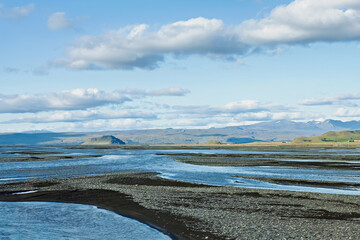 View of a unique Icelandic landscape with flowing water and clouds