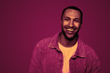 Obraz premium Handsome man smiling in neon light, space for text