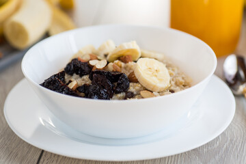 Healthy oatmeal with banana, nuts and prunes