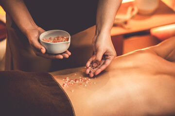 Woman customer having exfoliation treatment in luxury spa salon with warmth candle light ambient....
