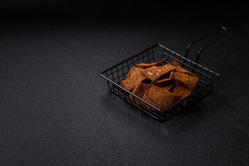 Crispy homemade brown bread chips with seeds and grains, salt, spices