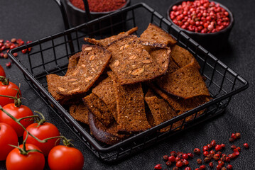 Crispy homemade brown bread chips with seeds and grains, salt, spices