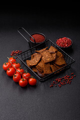 Crispy homemade brown bread chips with seeds and grains, salt, spices