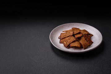 Crispy homemade brown bread chips with seeds and grains, salt, spices