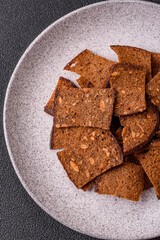 Crispy homemade brown bread chips with seeds and grains, salt, spices
