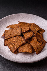 Crispy homemade brown bread chips with seeds and grains, salt, spices