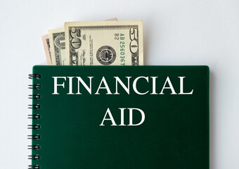 On white background, a calculator, a white sheet with the text FINANCIAL AID, a pen. Business Concept