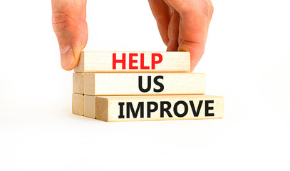 Help us improve symbol. Concept words Help us improve on beautiful wooden blocks. Beautiful white table white background. Businessman hand. Business motivational help us improve concept. Copy space.