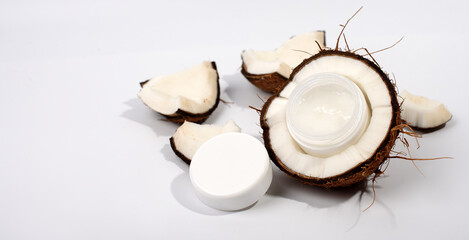 cosmetic cream and coconut on white background