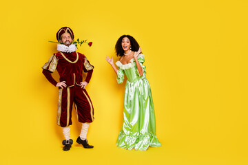 Two costumed individuals posing cheerfully against a bright yellow backdrop, dressed in elegant...