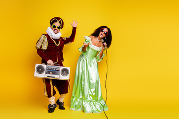 Couple Dressed in Historical Costumes Posing Against Vibrant Yellow Background