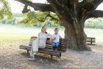 Mother and son sharing a moment together on a park bench