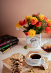 photo Cozy Coffee Time with Floral Decor, Stack of Crispy Cookies, Fresh Brewed Tea, and Relaxing Book Ambiance for a Calming and Peaceful Afternoon Break