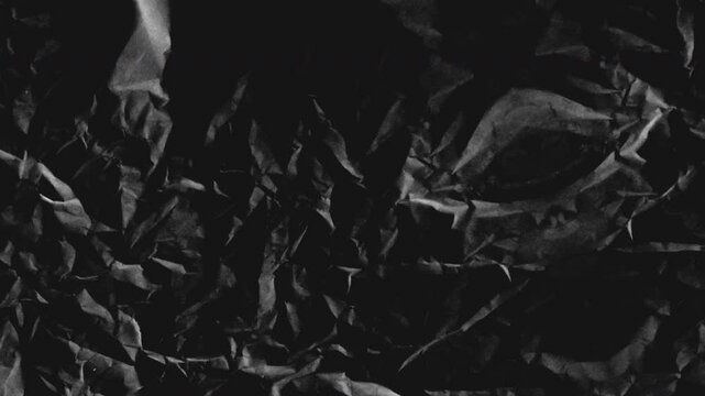Seamless loop animation features a black and white grunge, wrinkled paper texture as the background. Stop-motion backdrop overlay footage