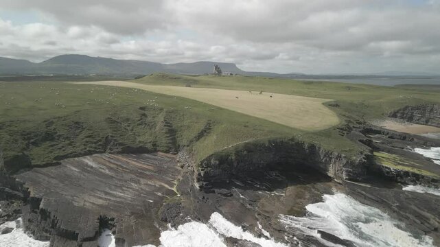 Clasby Castle against the backdrop of the picturesque landscape of Mullingar Head. Ireland