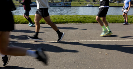 Fototapeta premium Motion blurred marathon runners in a city. Group of marathon runners compete in the race outdoors