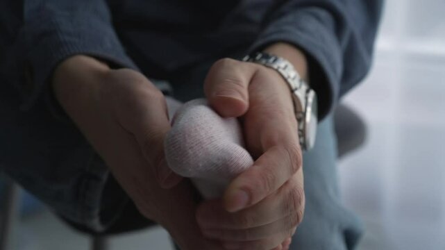 A man massages his sore leg in white socks.
A man touches his leg with his hands.
A man has pain in his legs.
Fatigue in humans
