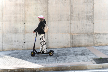 Woman riding electric scooter promoting sustainable mobility in urban area