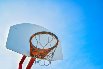 Basketball hoop net isolated on a clear blue sky background. Bright vibrant colors. Angled composition. Copy space for text.